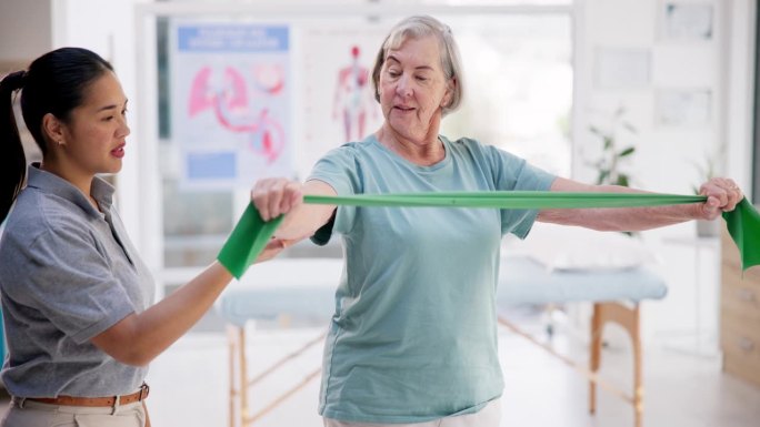 抗阻带、运动和老年女性在理疗器材、治疗师或帮助下进行康复训练。骨质疏松症、力量或伸展在诊所物理治疗师