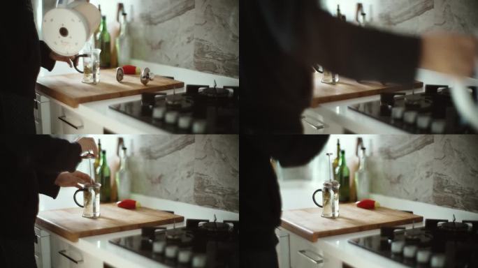 一名男子在厨房柜台上用法式压力锅煮红茶或早咖啡