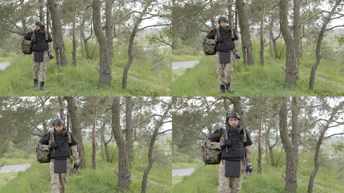 排雷。一个背着背包的士兵走在树林旁。中和矿山