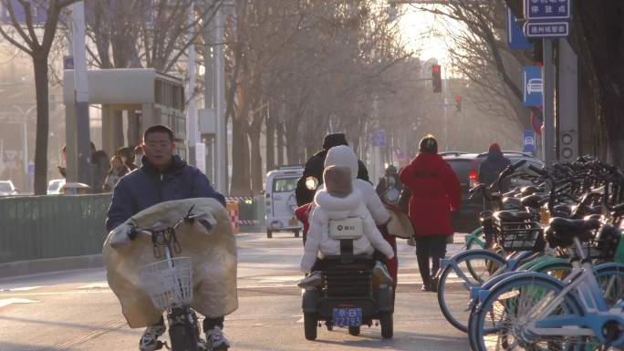 冬天太阳照在街道上班车流人流行人行色匆匆