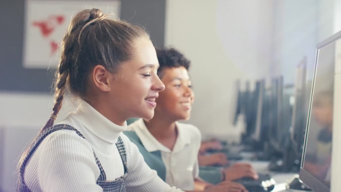 女中学生在信息技术课上坐在电脑屏幕前的肖像