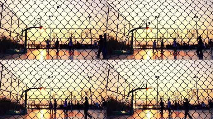 夕阳下篮球场打篮球的人升格镜头