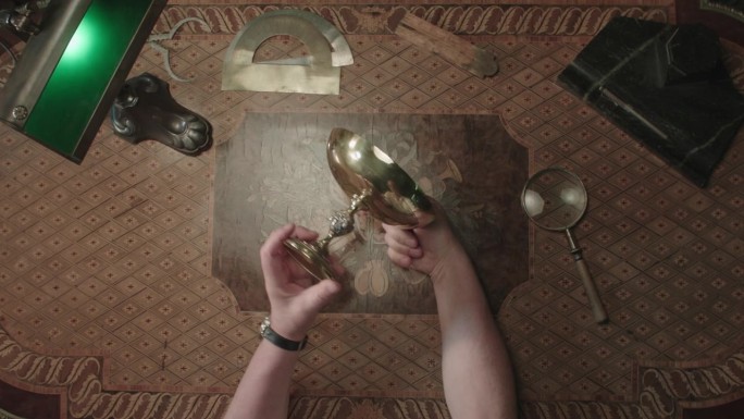 桌上的圣杯高脚杯被古物学家检查过了