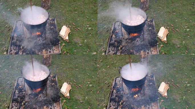 准备美味的罗马尼亚传统食品在大锅上的露天木火在大自然