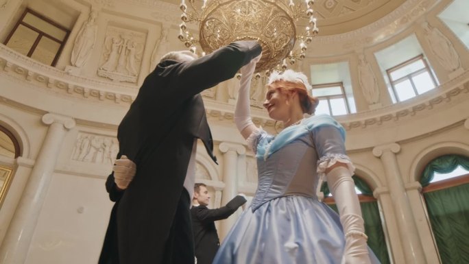 身着维多利亚式礼服的情侣在古典舞厅跳舞