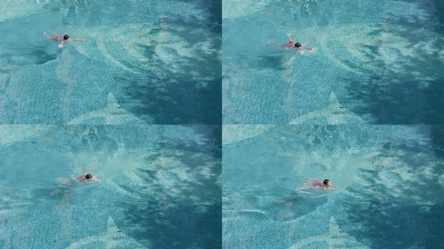 俯拍男孩在泳池里游泳
