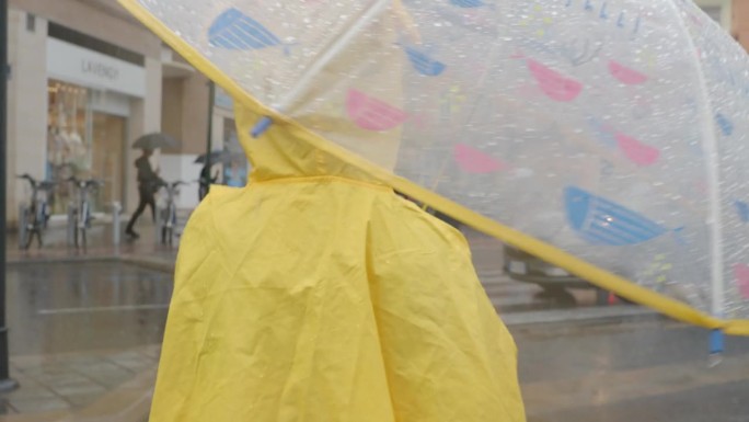 伞下穿黄色雨衣的女孩