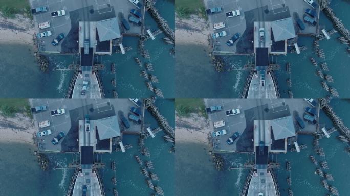 从上到下的无人机拍摄的轮渡在日出前卸载到纽约长岛的庇护岛北福克