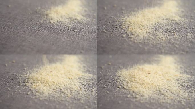 从碾碎的坚果上掉落的杏仁粉落在厨房布上，慢镜头特写