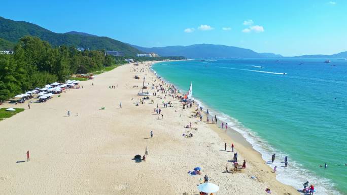海南三亚亚龙湾航拍蓝天白云海岸线上的游客