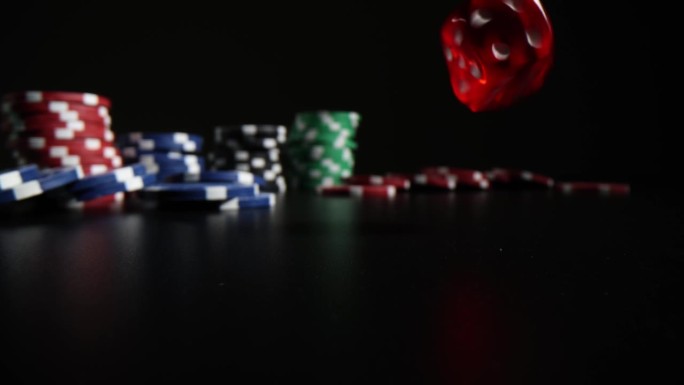 红色透明骰子落在一堆赌场筹码旁边