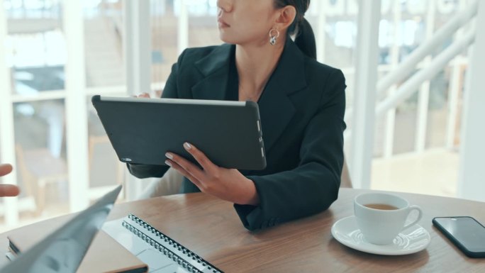 商务女性在开会时在平板电脑上打字，在办公室里与同事讨论和制定战略。认真的企业专业听讲、记笔记和浏览