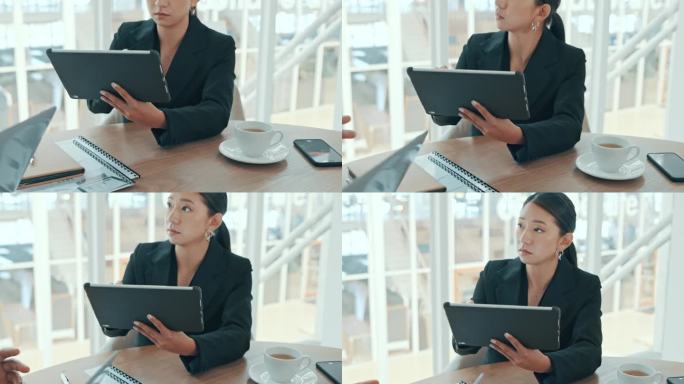 商务女性在开会时在平板电脑上打字，在办公室里与同事讨论和制定战略。认真的企业专业听讲、记笔记和浏览