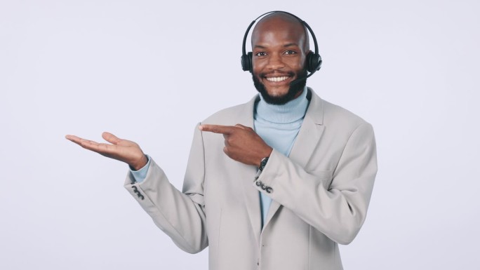 快乐的黑人，呼叫中心，指着手掌上的广告或名单，背景是一个工作室。非洲男性或顾问展示销售或折扣的客户服