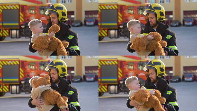 身着制服的消防员抱着获救的小男孩