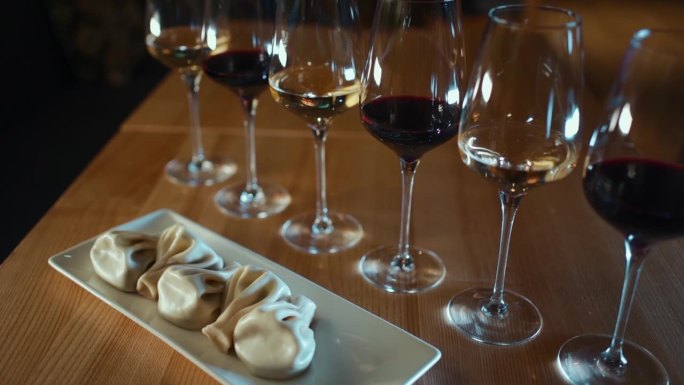格鲁吉亚的khinkali饺子，木桌上玻璃杯里装着红葡萄酒和白葡萄酒