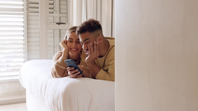 印度夫妇，放松一下，在卧室里用手机看社交媒体、电影直播或阅读网络新闻。微笑，快乐或爱的男人和女人对移