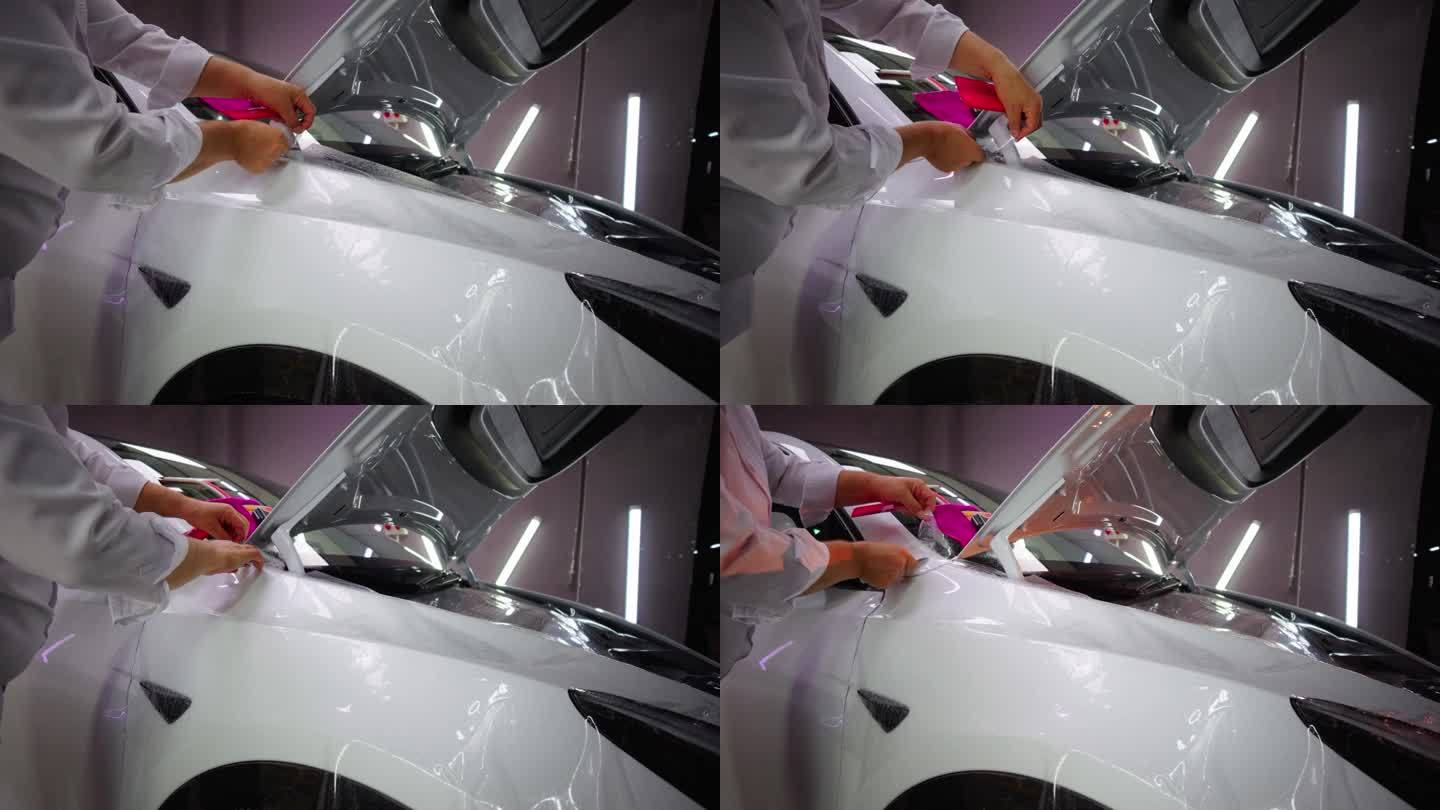一位男士用塑料刮刀在新车上涂保护膜。