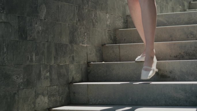 穿短裤的女孩正在下楼。街上的楼梯。