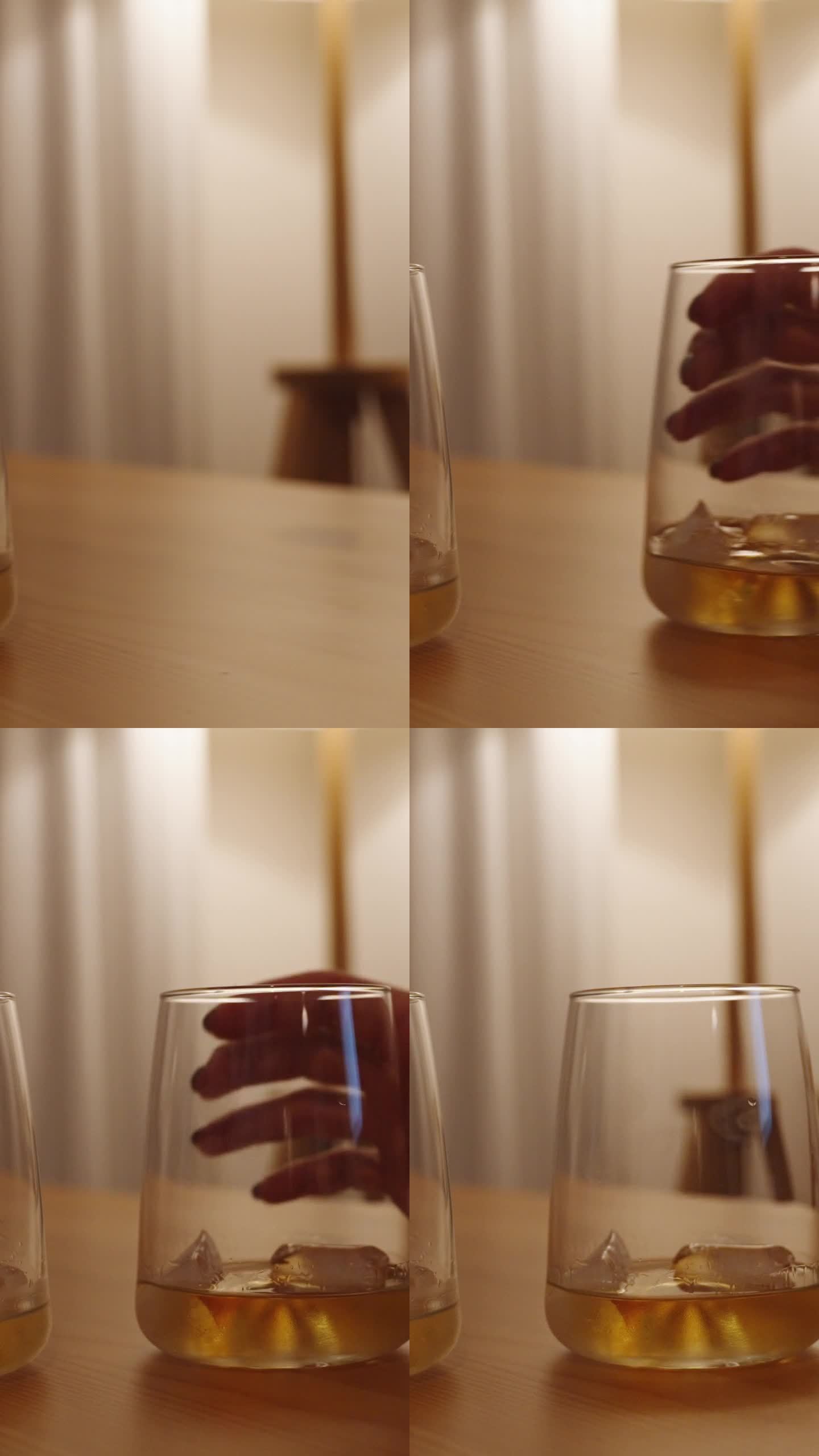垂直视频。男人和女人把他们的威士忌酒杯并排放在一张木桌上。这个场景是在一个白色的房间里被昏暗而温暖的