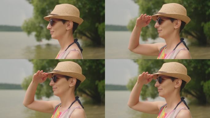 一个快乐的年轻黑发女人，戴着帽子和太阳镜，在海滩度假，微笑的慢动作