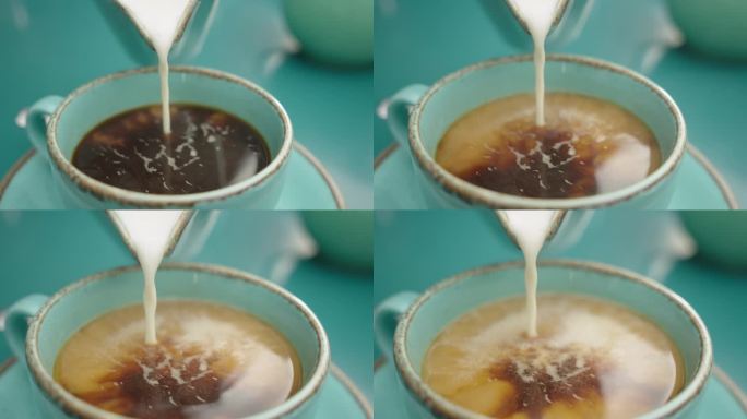 往热咖啡里倒牛奶。慢动作