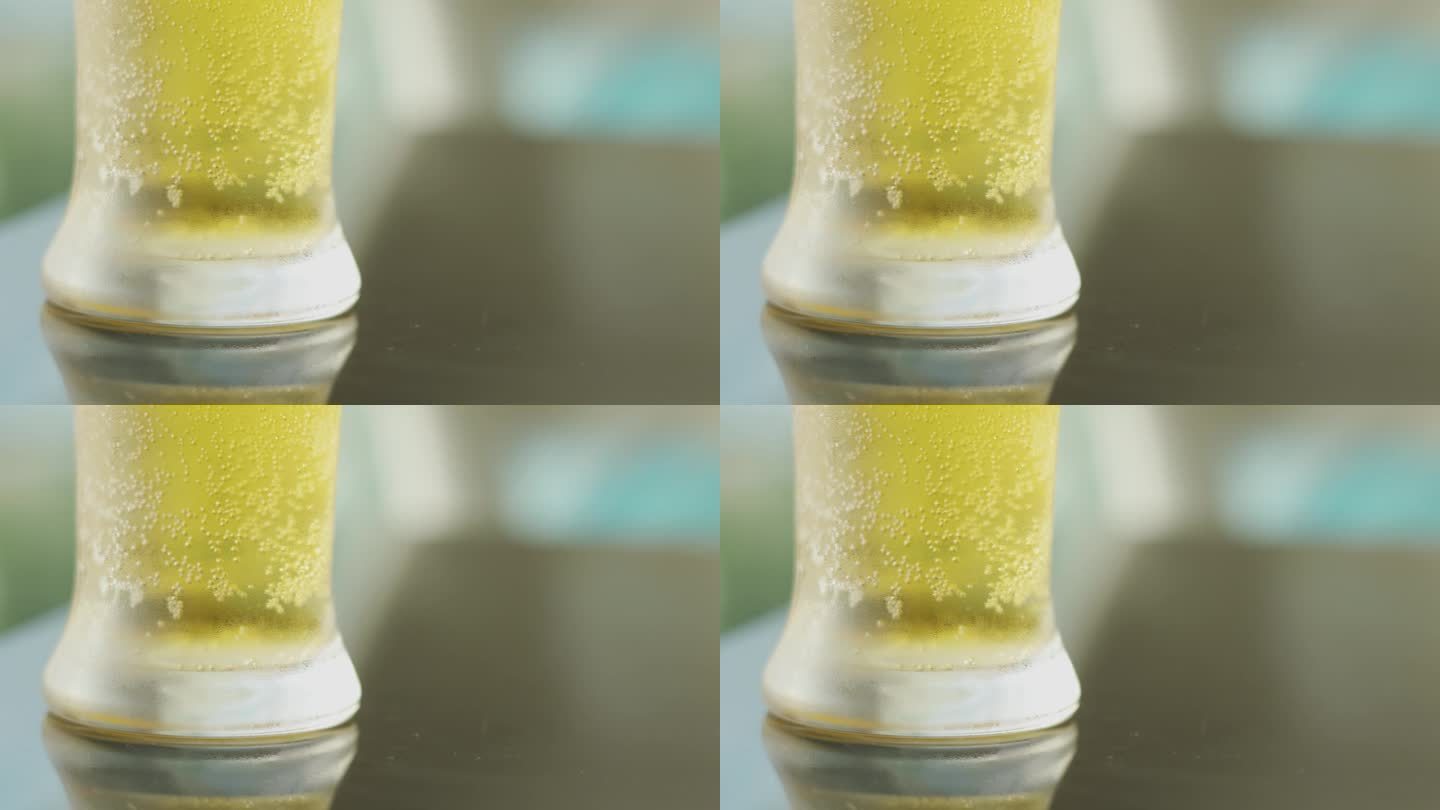 木桌上冰镇的、金黄的酿啤酒的玻璃底，冰凉的液体闪烁着一种闪闪发光的魅力，杯子里折射出一种庆祝和放松的
