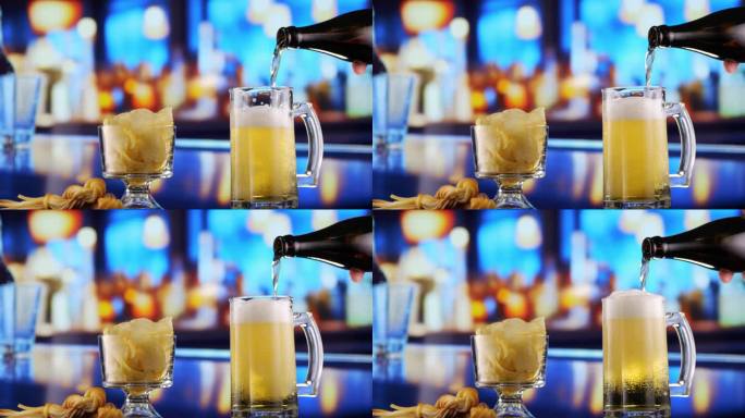 啤酒倒进玻璃杯，形成气泡和泡沫。酒吧里有小吃和薯条。特写，微距镜头。啤酒抓住了啤酒节庆祝活动的精神