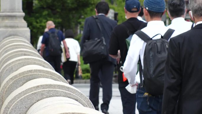 日本，大阪:一群人走在商业区的背影。