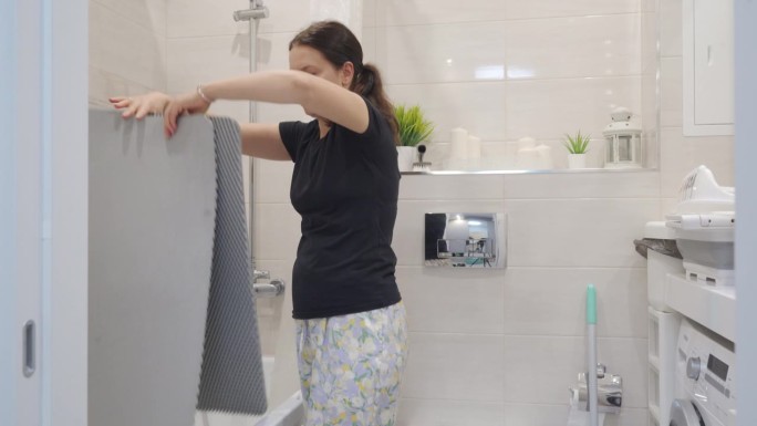 妇女在家打扫浴室，家庭主妇打扫橡胶地垫
