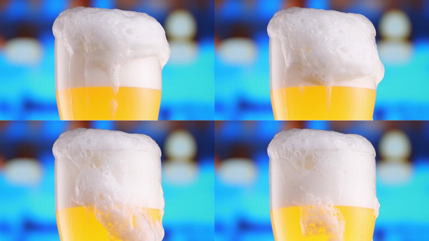 啤酒在啤酒杯中，形成冒泡的气泡和泡沫的头部。啤酒泡沫顺着玻璃杯流下细节拍摄，微距拍摄。啤酒抓住了十月