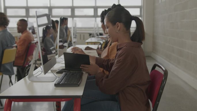 女大学生在学校的计算机课上记笔记