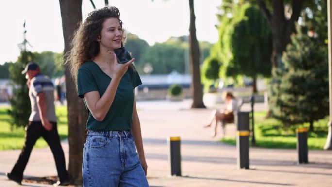 年轻女子走在街上发语音信息