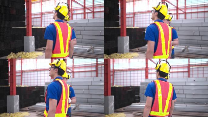 戴安全帽和安全帽的仓库工人站在仓库内清点和检查仓库内的钢材。