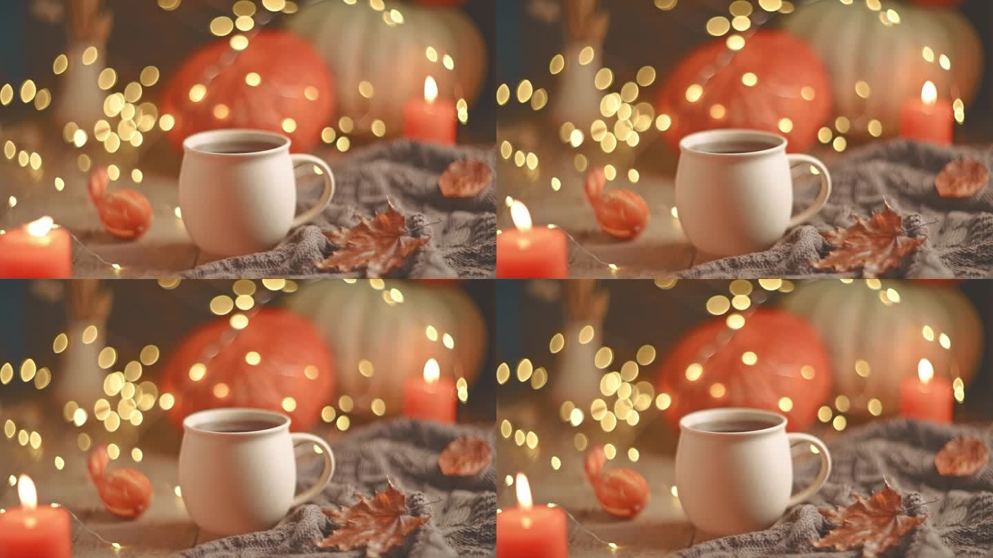 秋天惬意的构图。杯子里的茶，南瓜和蜡烛