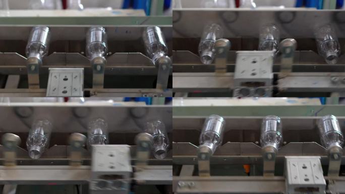 在泰国清迈的一家饮用水生产厂，塑料饮用水瓶在通向瓶子标签印刷过程的传送带系统中的视频片段。