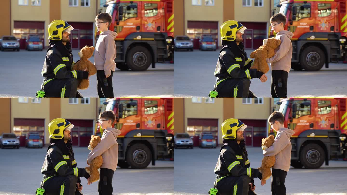 获救的小男孩和站在消防车旁的消防员的肖像。灭火行动中的消防员