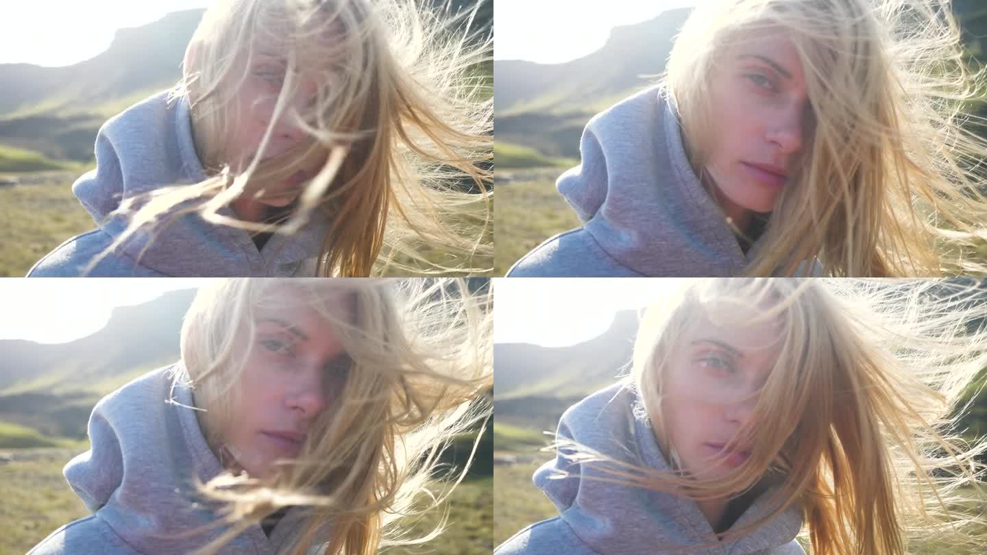 一个美丽的金发女人在阳光下的肖像，背景是冰岛南部令人难以置信的风景