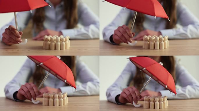一群木娃娃躲在红色的伞下