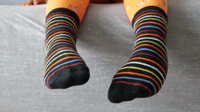 孩子脚上的彩色软袜子。