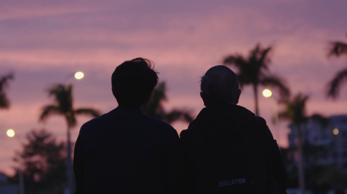 日落和老人在海边坐着散步交流