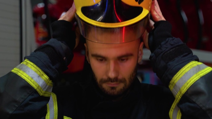 消防队员站在消防站，戴上防护头盔，准备行动
