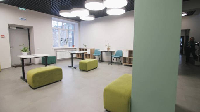 现代化的教室配有舒适的椅子、脚垫和课桌