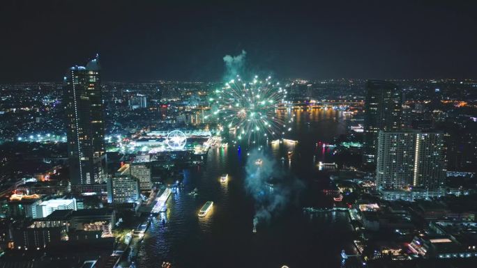 多色烟花表演在城市景观和摩天大楼庆祝夜晚的灯光，河流和曼谷大桥