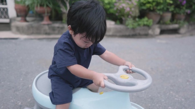 一个亚洲男孩在玩玩具车。有趣的骑。