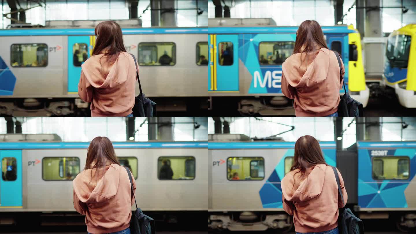 背着双肩包的女子在高速列车旁等地铁