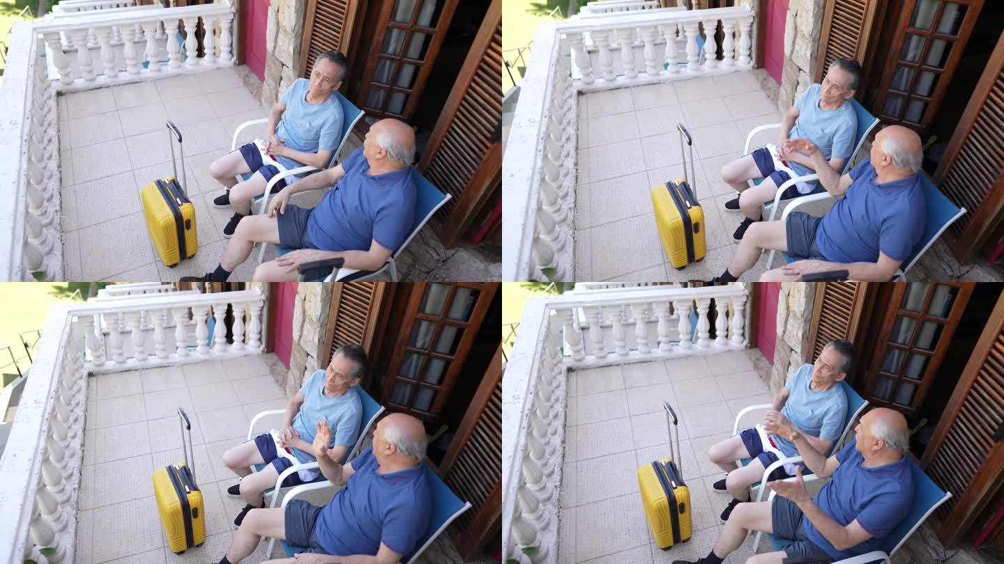 年长的朋友在酒店阳台上聊天