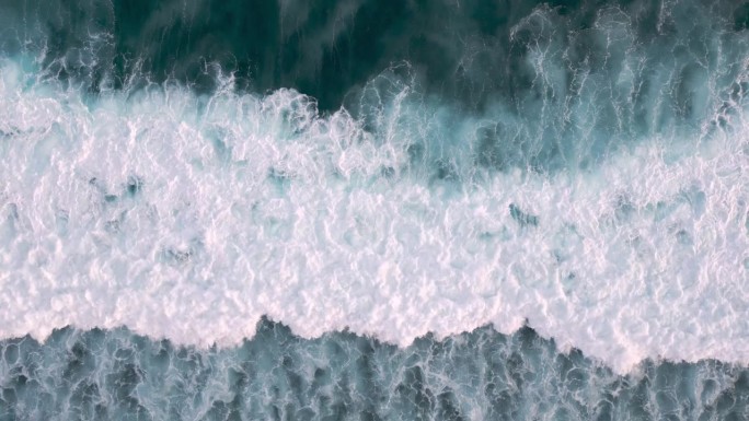 海浪与破潮蓝水的海景鸟瞰图。打破太平洋风和黑暗戏剧性风暴的野性。大海洋自由与极限野生动物的抽象概念