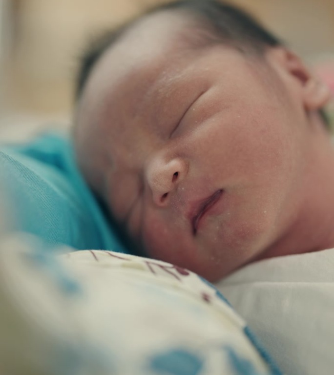 亚洲母亲和刚出生的男婴在医院病房拥抱爱——发自内心的母性和育儿时刻。