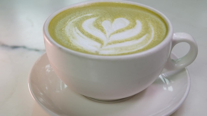 服务员把抹茶和绿色泡沫放在桌子上。代替卡布奇诺减少咖啡因的摄入，用更健康的玛咖茶代替。素食者对日本茶